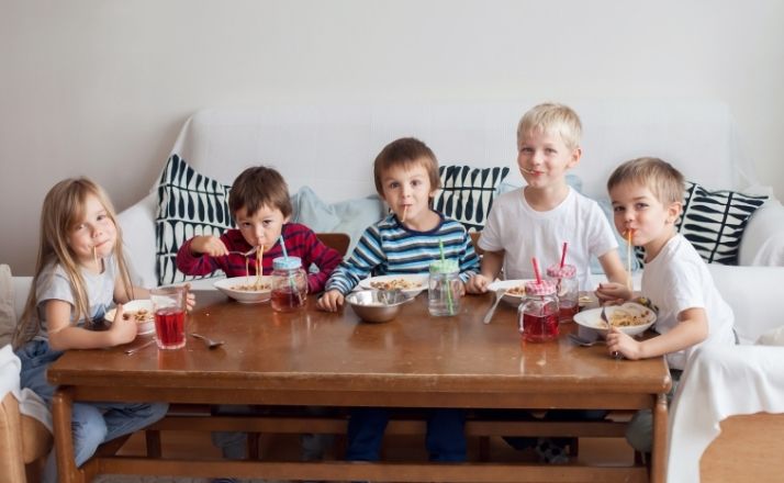 Big family with multiple kids eating cereal at a coffee table