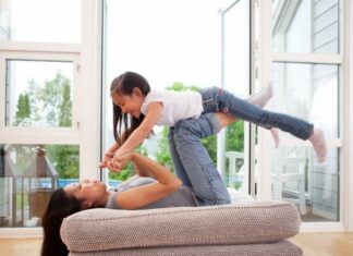 Mom holding up daughter with her knees and hands as an example of how to lift them up while you can