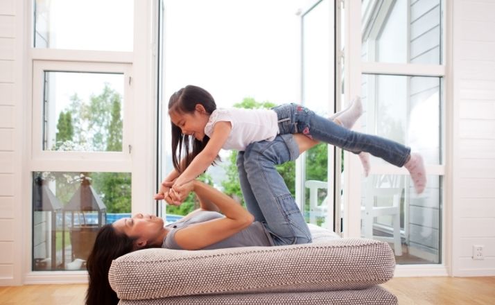 Mom holding up daughter with her knees and hands as an example of how to lift them up while you can