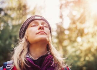 Woman in forest with eyes closed seeming content that her parent is dead