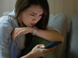 woman staring at phone when being stalked online