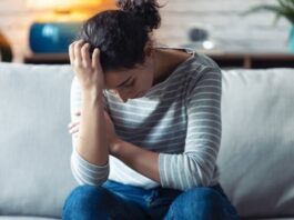 woman with head down on one hand experiencing anxiety