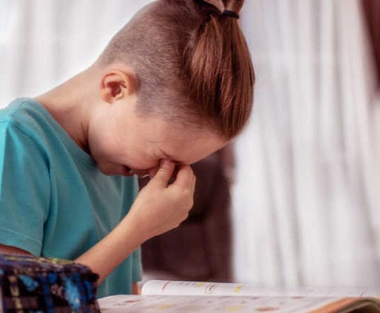 Cute schoolboy appearing to be frustrated while doing his homework