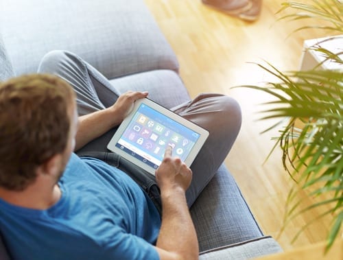 smart house, home automation, device with app icons. Man uses his tablet PC with smarthome app to control his house. the new generation of the internet of things.