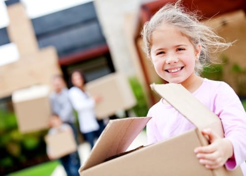 Girl moving house with his family and carrying boxes