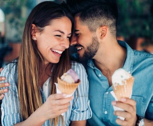 Couple laughing over ice cream on a date night out