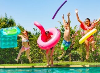 kids jumping into a backyard pool