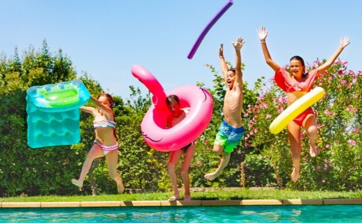 kids jumping into a backyard pool