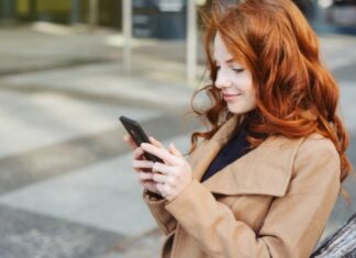 Woman smiling and creating better tweets on Twitter on her cellphone