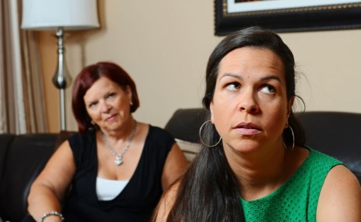 Woman rolling her eyes at older woman behind her giving her advice about depression