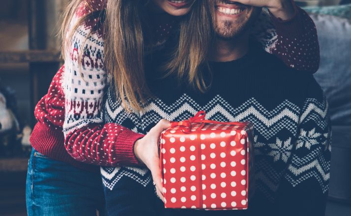 wife surprising husband with a gift after the stress of gift buying for difficult people