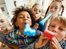 Kids' birthday party with group of kids holding blowouts