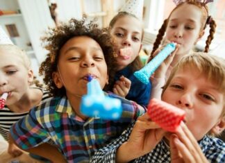 Kids' birthday party with group of kids holding blowouts