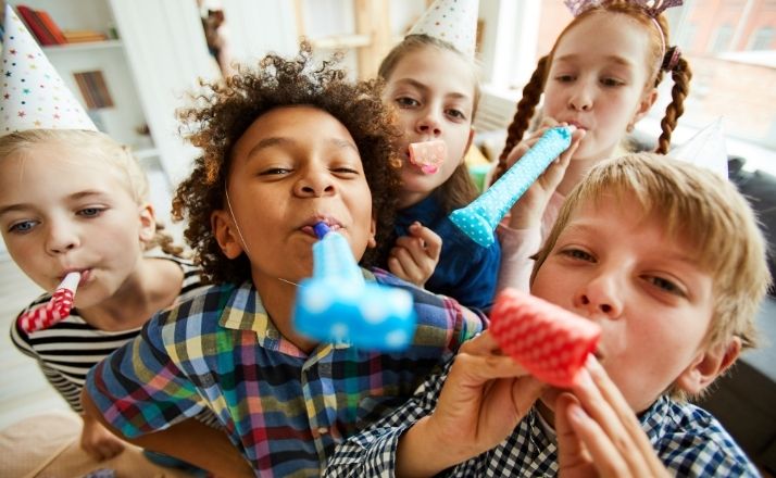 Kids' birthday party with group of kids holding blowouts