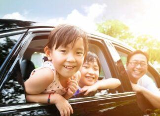 Smiling family hanging out windows of one of the best vehicles for families