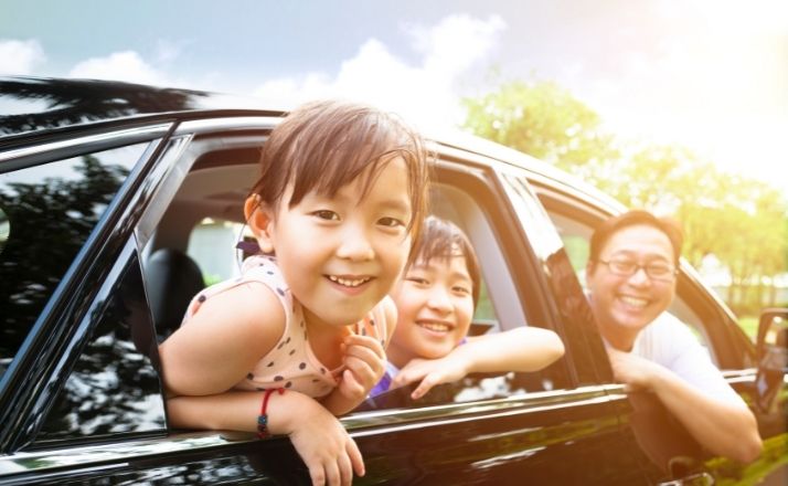 Smiling family hanging out windows of one of the best vehicles for families