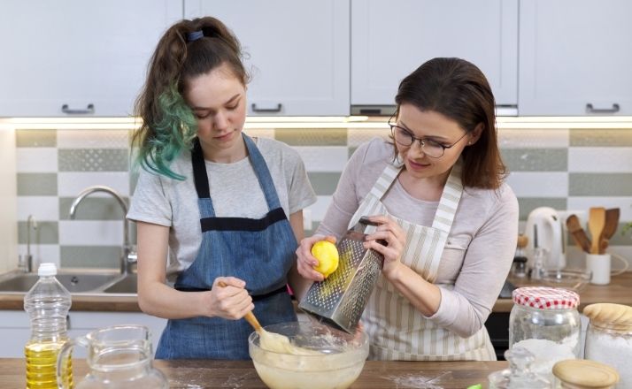 mom and teen daughter in kitchen cooking and learning life skills