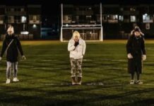 women standing in a football field screaming