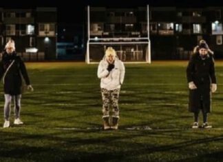 women standing in a football field screaming