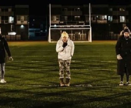 women standing in a football field screaming