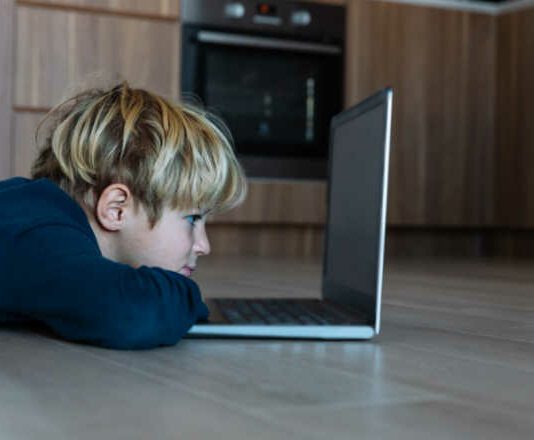 kid looking at computer at home, online learning and remote education kids' mental health