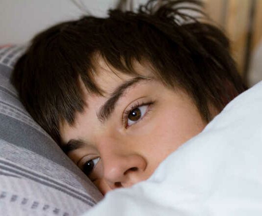 teenager sleeping in bed