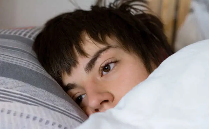 teenager sleeping in bed