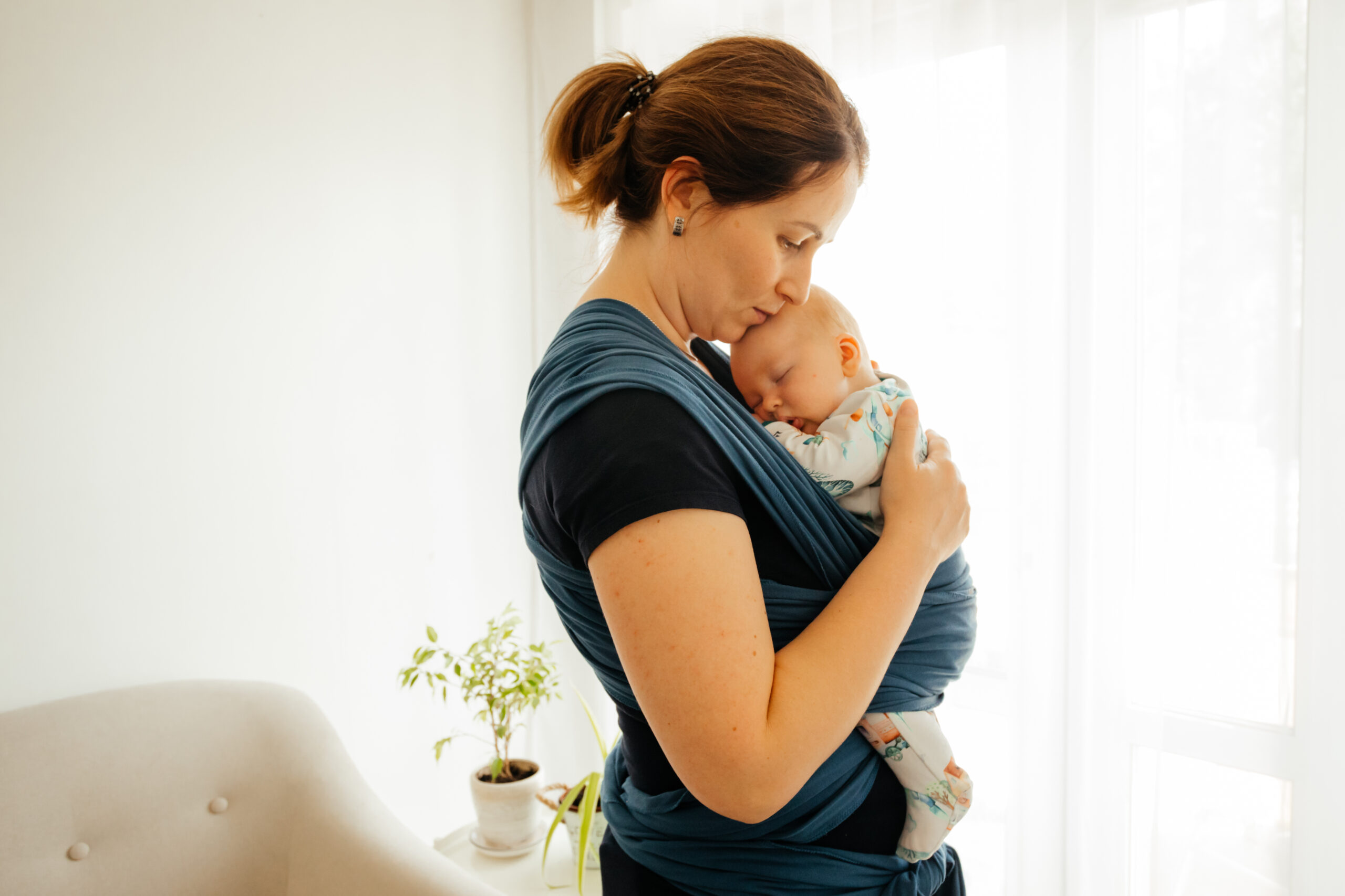 mom cuddling baby in carrier