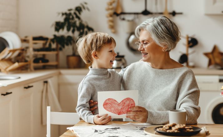 child giving his Grandma a card for Grandparents Day