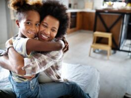 mother and daughter hugging and smiling in the kitchen on National Daughter's Day