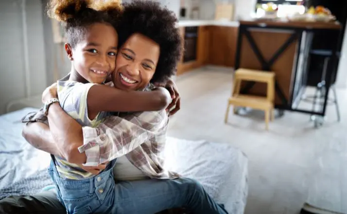 mother and daughter hugging and smiling in the kitchen on National Daughter's Day