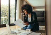 Woman sitting on floor printing from her laptop as one of SAHM jobs