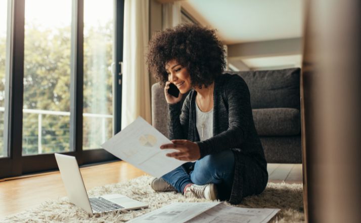 Woman sitting on floor printing from her laptop as one of SAHM jobs