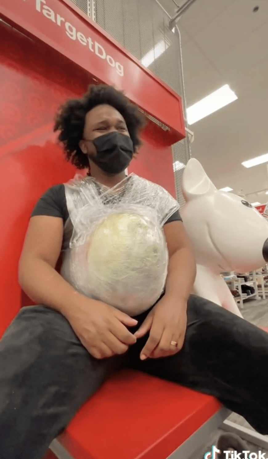 Man with watermelon on belly sitting in Target store