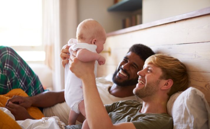 couple holding a baby and smiling to show reader if you are ready to adopt a baby