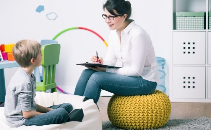 boy with child psychologist on bean bag chairs