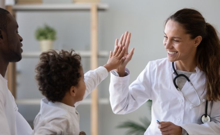 child high-fiving a medical child specialist