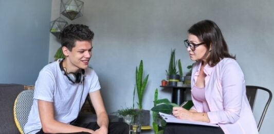 teen talking with child therapist in office