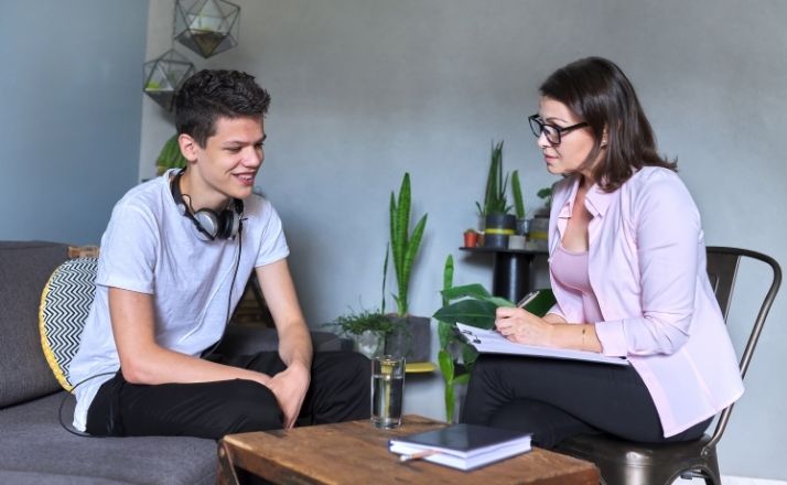 teen talking with child therapist in office