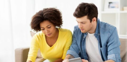 couple with calculator and paper wondering how much does it cost to adopt a child