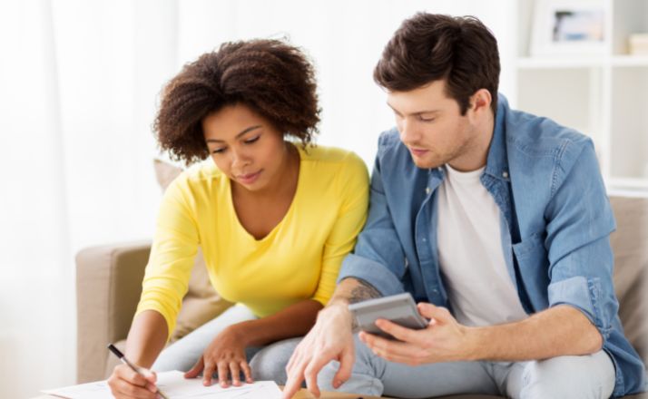 couple with calculator and paper wondering how much does it cost to adopt a child