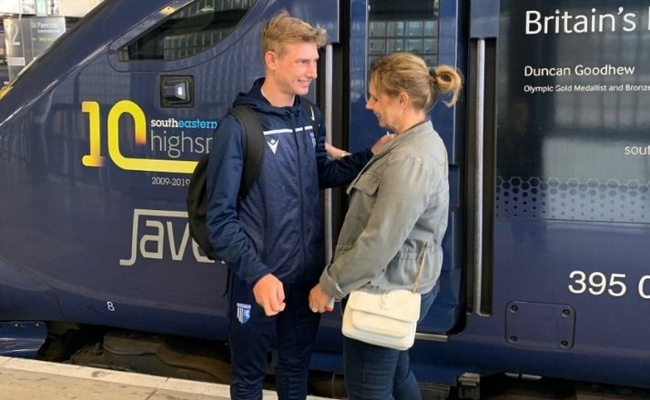 Teenage son saying goodbye to mom in front of a train