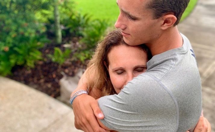 Teenage son hugging mom before moving out leaving her with an empty nest