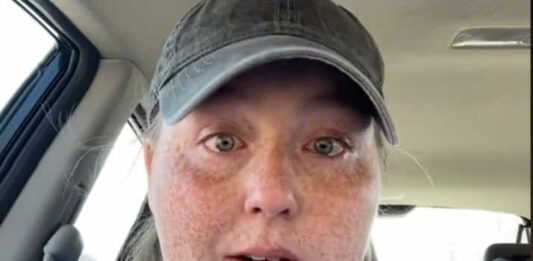 woman crying in car with hat on