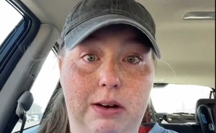 woman crying in car with hat on
