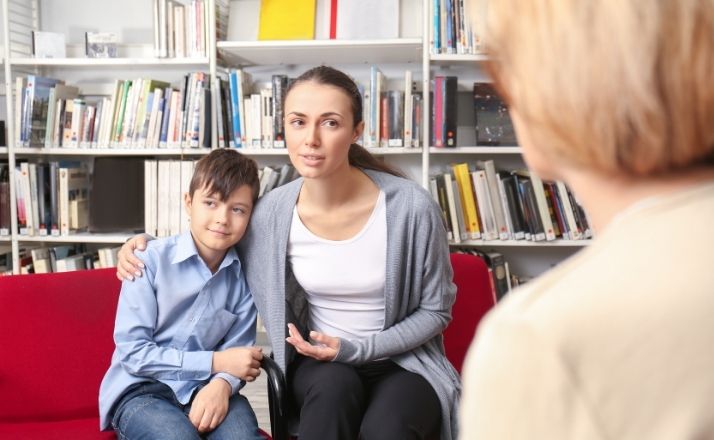 Mom and son sitting on couch talking to therapist