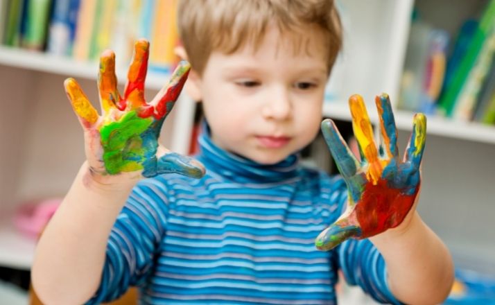 boy with paint on his hands in sensory processing disorder therapy