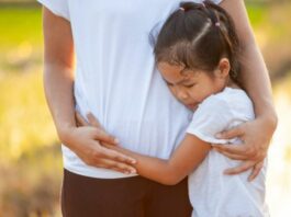 sad daughter hugging her dad while showing signs of trauma bonding