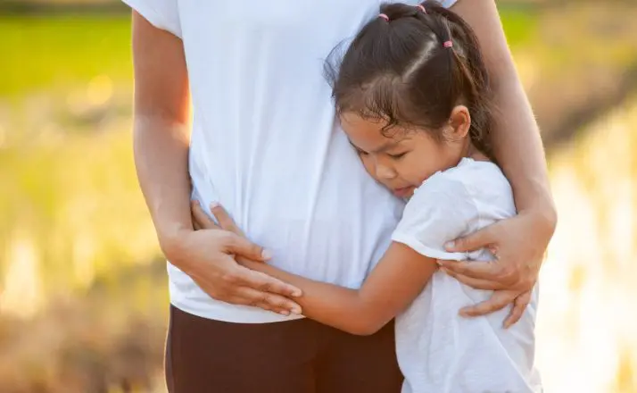 sad daughter hugging her dad while showing signs of trauma bonding