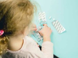 Young child play alone with pills tablets at home. Keep away from children reach concept. No medicine cabinet, raise awareness.